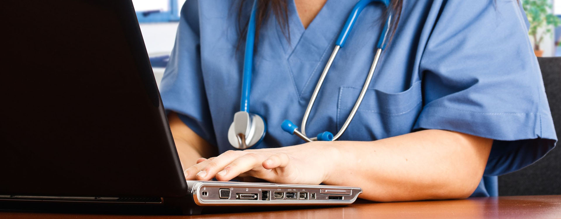 medical professional typing on a laptop