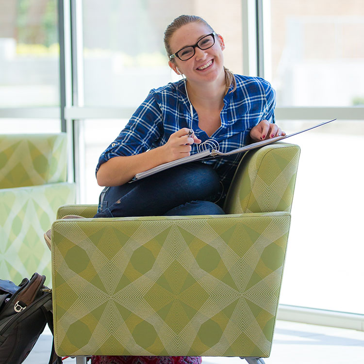 student sitting in a chair and smiling